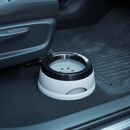 White and black pet water bowl placed on the floor of a car next to a seat and rubber floor mat