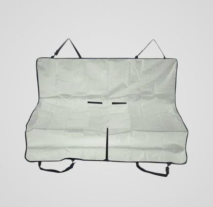 Folded light gray car seat cover with black straps on a plain background